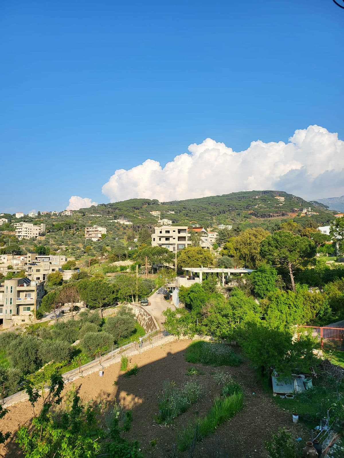 A view across the village of Mimess and its surrounding green hills